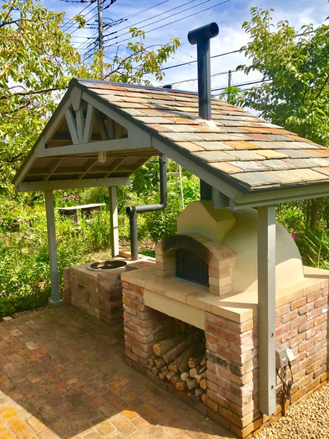草花に囲まれた素敵なお庭に屋根付きのピザ釜とかまどが出来ました。