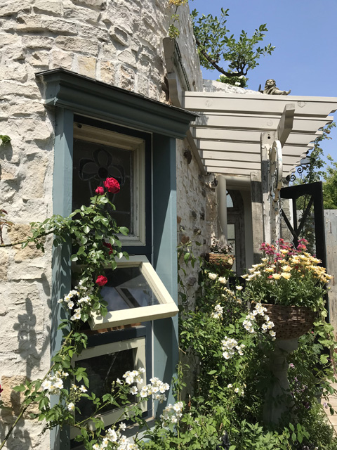ミニパーゴラに花壇そしてかわいい窓のある小屋